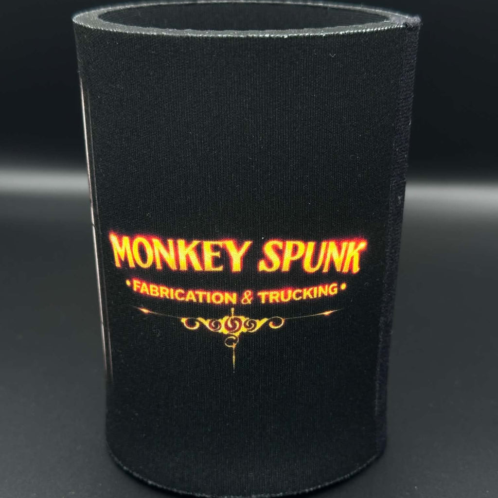 A black neoprene can cooler sleeve featuring the text 'MONKEY SPUNK FABRICATION & TRUCKING' in orange and yellow lettering, set against a dark gray background.